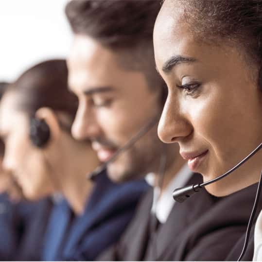 A group of answering service agents wearing headsets are standing by for an influx of calls.
