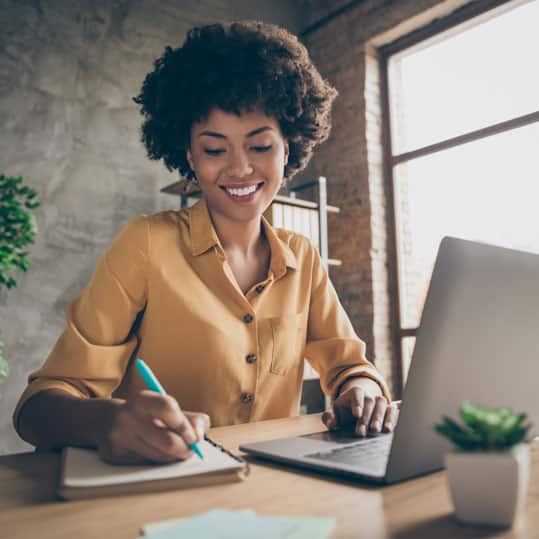 A young business owner in her office at home is peacefully taking care of tasks that her business requires without being distracted in answering phone calls.