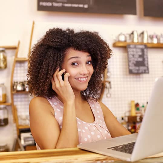 A small business owner is on the phone with the live answering service agency and is happy with the results.